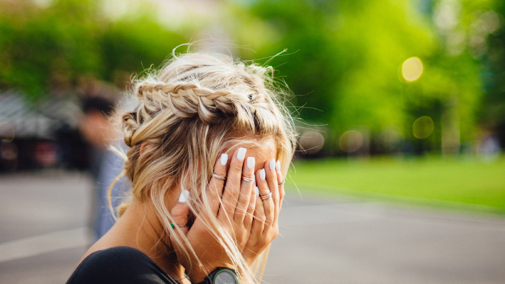 Women with a migraine in park.
